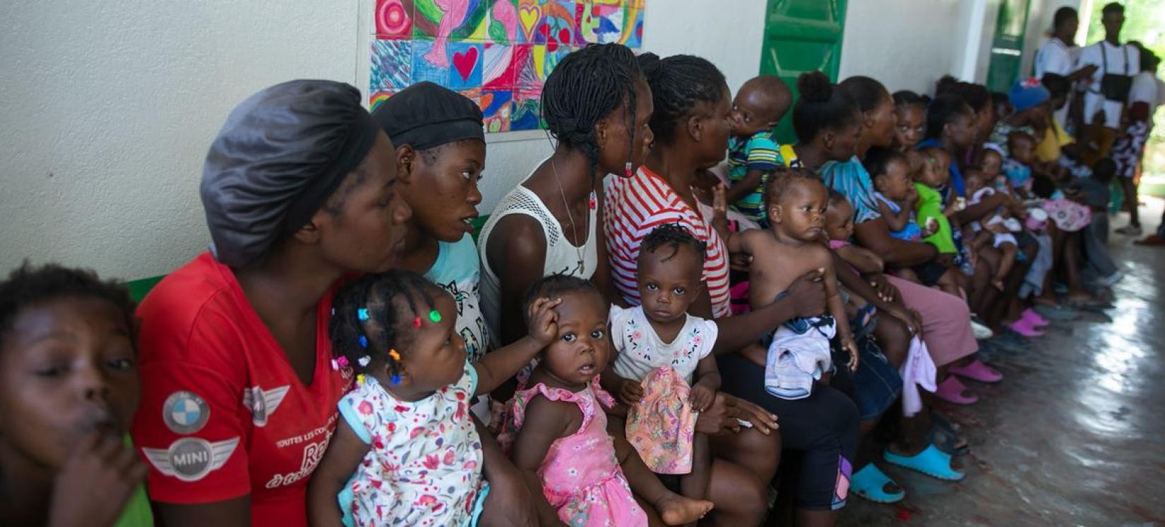 Des femmes et leurs enfants attendent dans une clinique mobile soutenue par l'UNICEF à Port-au-Prince, en Haïti.