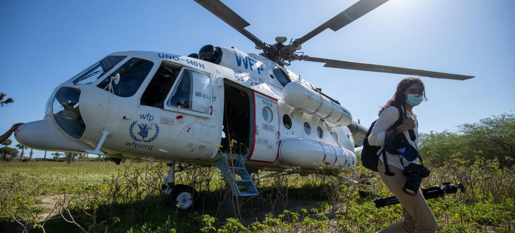 A passenger arrives on an UNHAS helicopter.