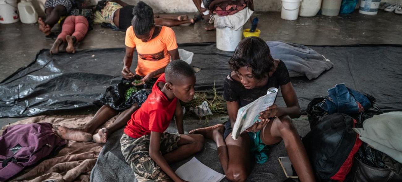 Une mère aide son enfant à étudier à l'arène de Boxe Olympique Delmas 4 où ils sont désormais hébergés.